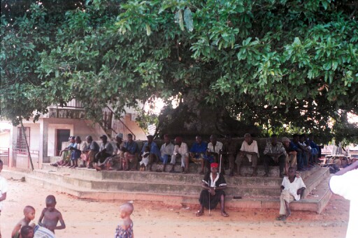Villagers sitting under the shade of a big tree